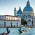 Gondoliers on gondola at Grand Canal in Venice. Basilica Santa Maria della Salute in sunny day